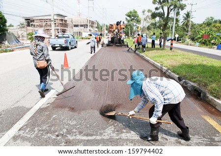 Group of workers working on Asphalt paving with Para Slurry Seal Truck on road renovation