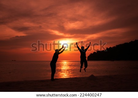 happy celebrating winning success people jumping holding sun silhouette