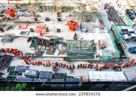 Bangkok, Thailand - November 9, 2014 - Construction site along the sky train lines in Bangkok - workers line up to leave the site going home at the end of day work.
