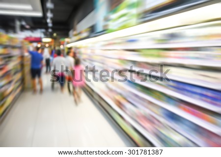blurred image of supermarket people shopping motion blur- product shelf - business concept