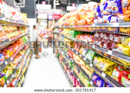 blurred image of supermarket people shopping - product shelf - business concept