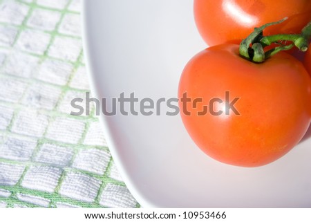 The tomato placed on the white plate.