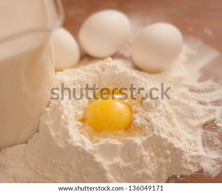 food - flour, egg, milk and a broken egg for a recipe