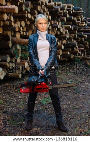 Young pretty woman with huge red chainsaw