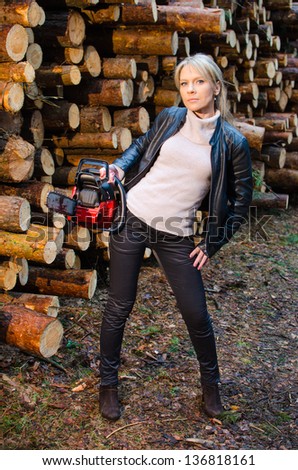 Young pretty woman with huge red chainsaw