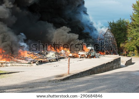 Huge fire of buildings and cars in industrial area of Vilnius, Lithuania. Black smoke is rising up to the sky. Representative picture for insurance, damage, loss, accidents and other situations.