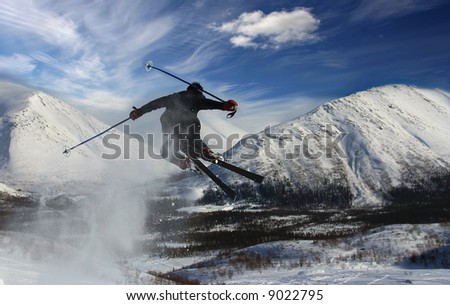 The skier in mountains in flight from a back has jumped from a springboard
