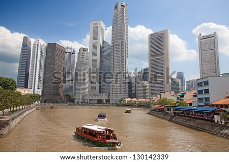 SINGAPORE - FEBRUARY 22: A tourist boat cruising Singapore river, on February 22, 2013 in Singapore. The Singapore River Cruise is a tourist attraction in this former British colony.