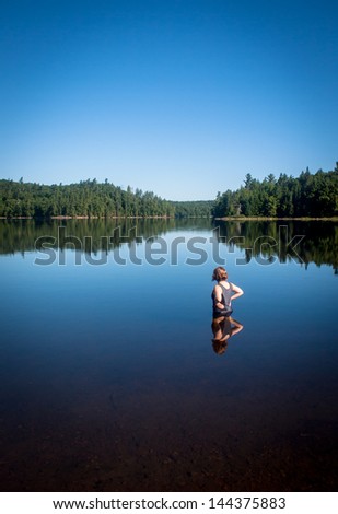 the girl in the lake in the canadian park under the blue sky