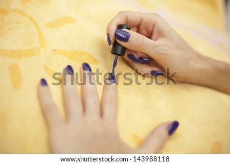 Woman applying purple nail polish - manicure