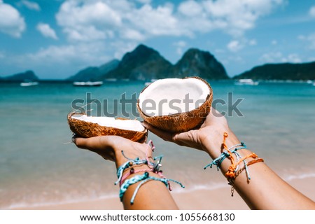 POV: coconut in girl hands on the tropical beach over sea landscape. Travelling tour in Asia: El Nido, Palawan, Philippines.
