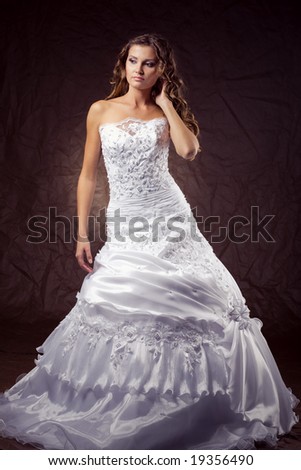 stock photo Fashion model wearing wedding dress at brown studio background