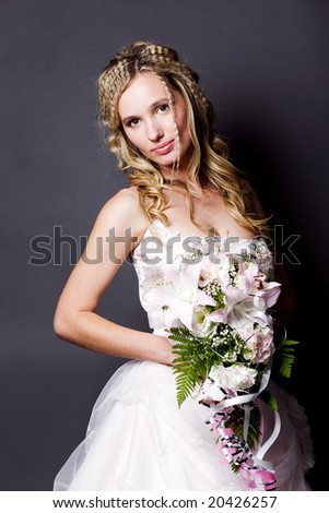 stock photo Beautiful blond bride wearing wedding dress posing on gray 