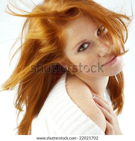 Sexy girl with red hair and freckles posing on white studio background
