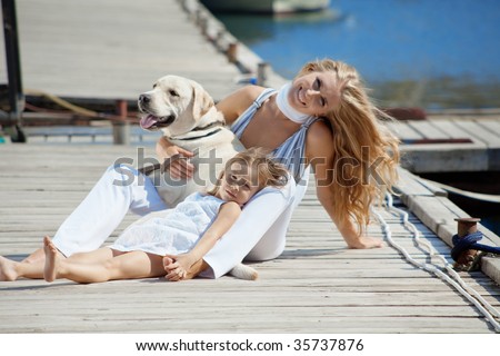 Happy family with dog on berth in summer