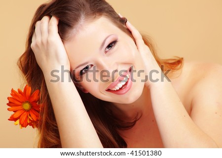 Studio portrait of beautiful smiling woman with flower
