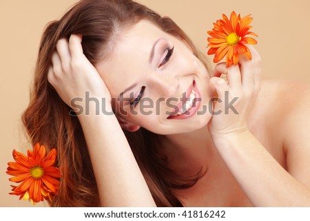 Studio portrait of beautiful smiling woman with flower