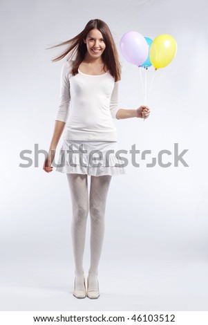 Fashion shot of young beautiful woman holding holiday balloons in her birthday