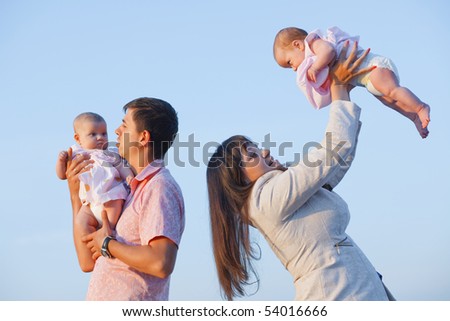 Young parents with children kissing over sea