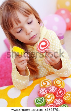 Cute child eating candies at home