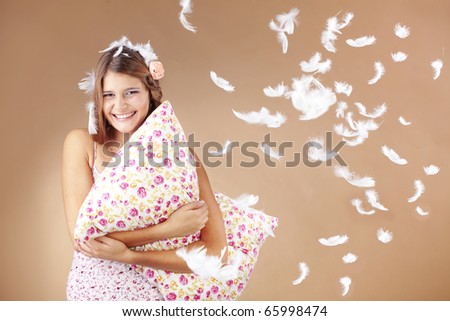 Beautiful teenage girl holding a pillow studio shot