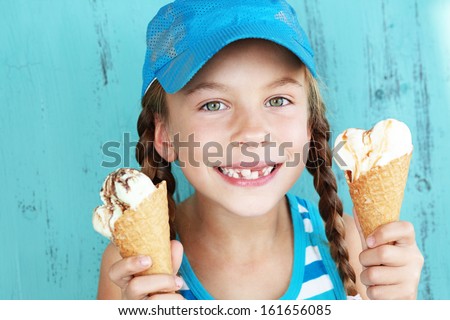Portrait Of 7 Years Old Kid Girl Eating Tasty Ice Cream Over Blue