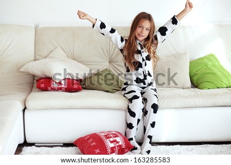Portrait of child in soft warm cow print pajamas waking up at morning