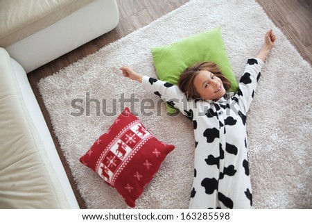 Portrait of child in soft warm cow print pajamas waking up at morning