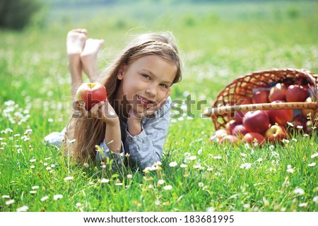 Child eating apple in a spring floral field