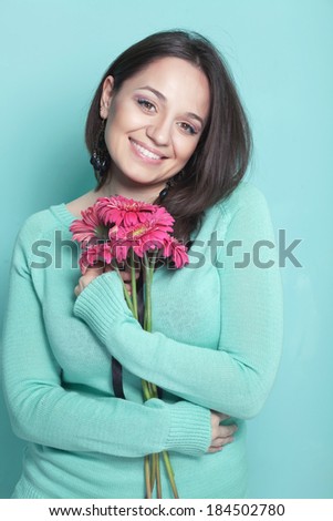 Portrait of woman holding bouquet of pink daisy