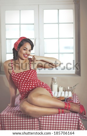 Vintage retro photo of pin up girl in the kitchen at house