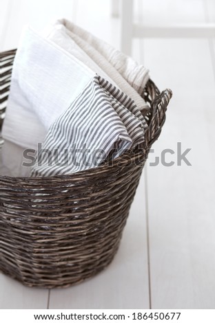 Wicker clothes basket with cotton linen in it