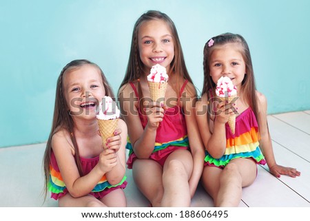 Group of children dressed in fashion swimsuits posing on aqua blue background