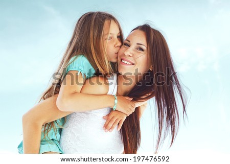 Mother with her 7 years old daughter having fun at beach in summer