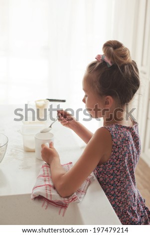 7 years old school girl cooking at the kitchen, casual lifestyle photo series