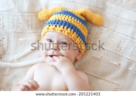 Portrait of a cute 4 months baby wearing crochet knit hat, top view point