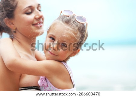 Happy family resting at beach in summer, mother with her 4 years old child