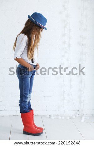 Cute teenage girl 8-9 years old wearing trendy hipster clothes posing over white brick wall