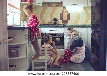Mother with three kids cooking holiday pie in the kitchen to Mothers day, casual lifestyle photo series in real life interior