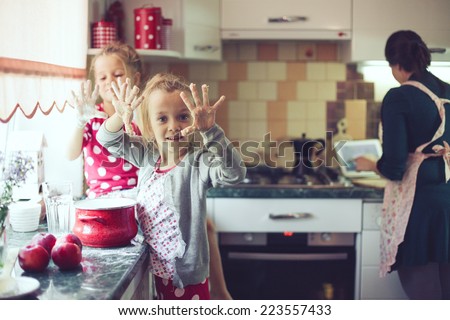 Mother with her 5 years old kids cooking holiday pie in the kitchen, casual lifestyle photo series in real life interior