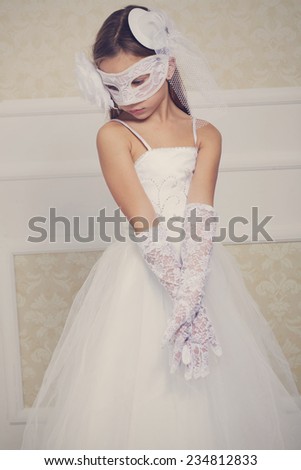 Portrait of a fashion girl wearing wedding dress and venetian mask