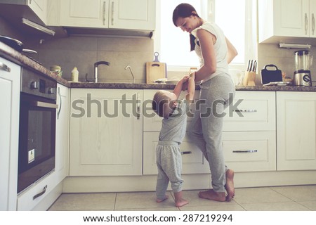 Mom with her 2 years old child cooking holiday pie in the kitchen to Mothers day, casual lifestyle photo series in real life interior