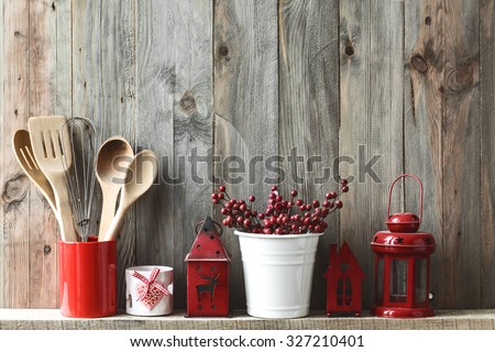 Kitchen cooking utensils in ceramic storage pot and Christmas decor on a shelf on a rustic wooden wall