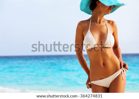 Beautiful woman's body in sexy bikini over beach background