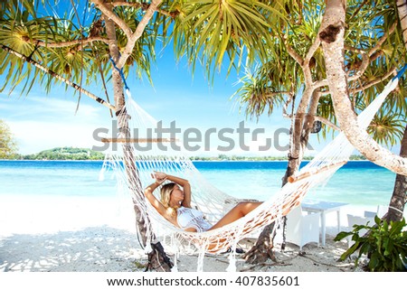 Woman relaxing in the hammock on tropical beach, hot sunny day