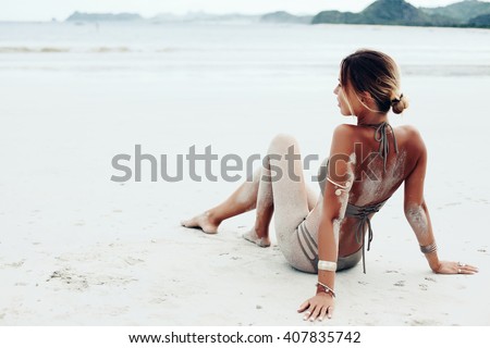 Beautiful bohemian styled and tanned girl at the beach