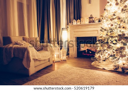Beautiful holiday decorated room with Christmas tree, armchair and fireplace at night. Led lighting, cozy home scene. Nobody there.
