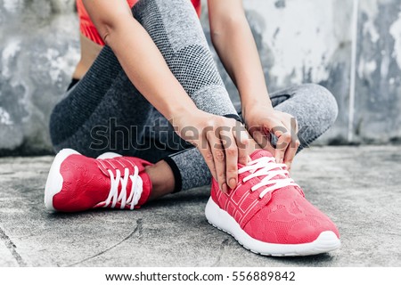 Fitness sport woman in fashion sportswear doing yoga fitness exercise in the city street over gray concrete background. Outdoor sports clothing and shoes, urban style. Tie sneakers.