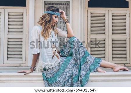 Fashion girl wearing bohemian clothing posing in the old city street. Boho chic fashion style.