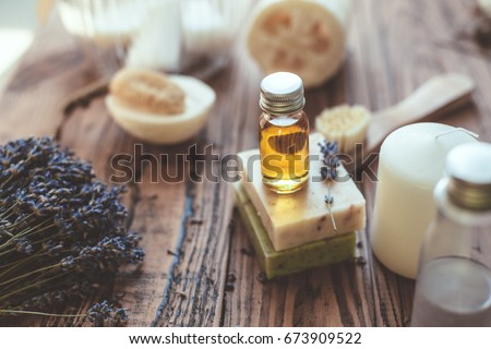 Natural spa products and decor for bath. Handmade herbal soap, organic oil, lavender, loofah and beauty products on wooden desk, closeup photo.